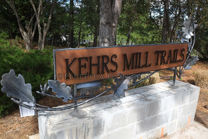 Decorative iron subdivision sign under construction.